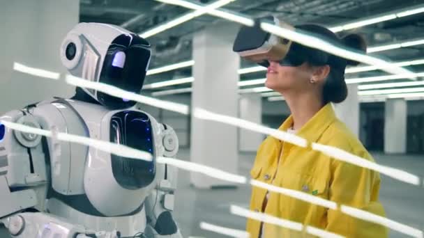 Lovely woman in VR-glasses is touching robots hand — Stock Video