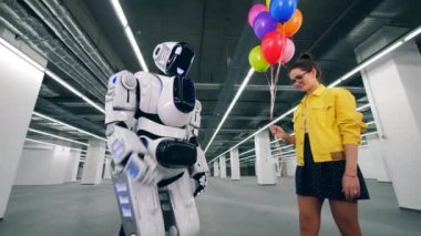 Gülümseyen kız bir cyborg renkli balonlar veriyor