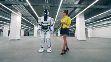 Tabletli genç bir kadın bir cyborg 'u değiştiriyor.