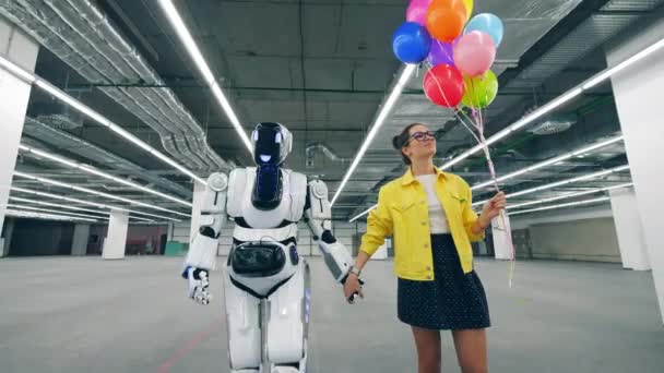 Eine Dame und ein Roboter gehen gemeinsam durch die Halle — Stockvideo