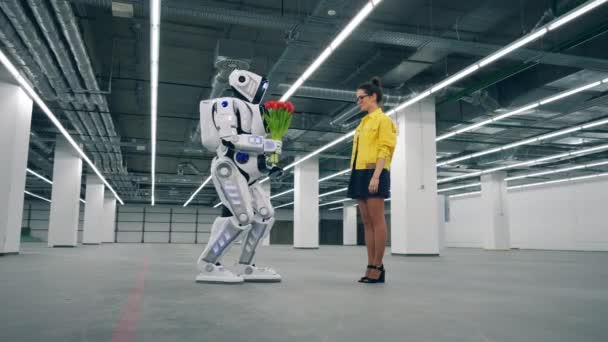 Lovely lady is accepting flowers from a human-like robot — Stock Video