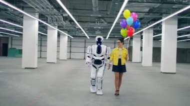İnsan gibi cyborg balonları tutan bir kızla yürüyor.