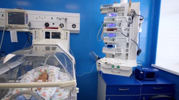 Een pasgeboren baby liggend in een ziekenhuisbed in een kamer. — Stockvideo