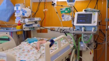 Hastane koğuşunda yatakta yatan çocuk, tedavi görüyor.