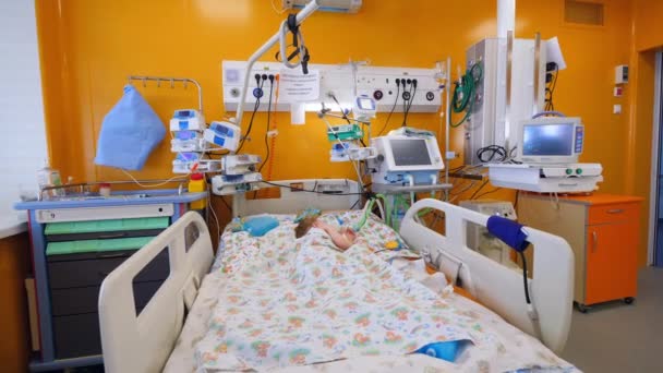 Klein meisje slaapt in een medisch bed in een klinische kamer. — Stockvideo