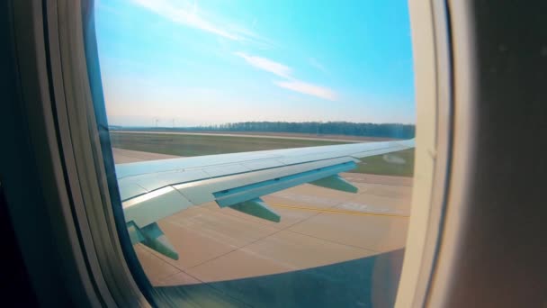 Conduites d'avion sur une piste, vue depuis une fenêtre de cabine . — Video