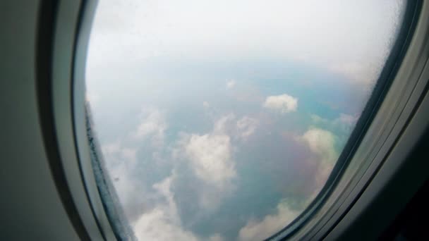 Plane window with the view on clouds during flight. — Stock Video