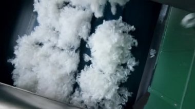 Beyaz polyester kumaş bir bitkinin taşıyıcısından düşer..