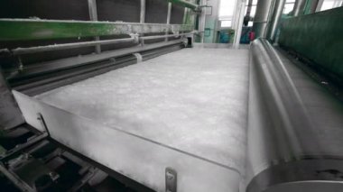 Haddeleme makineleri bir tesiste beyaz polyester kumaş ile çalışır.