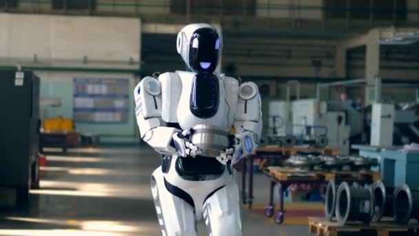 Cyborg está llevando un artículo de metal a través de la fábrica — Vídeo de stock