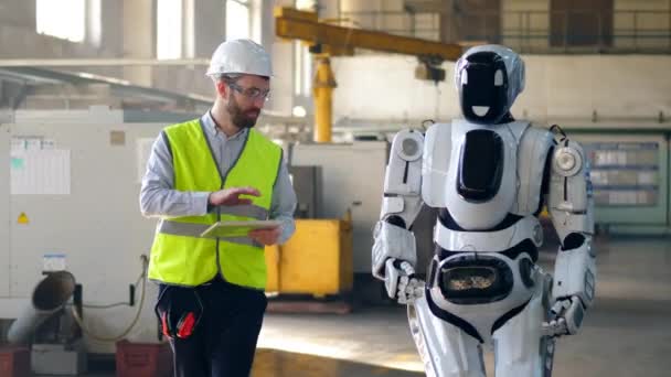 Técnico masculino está navegando un droide caminando — Vídeo de stock