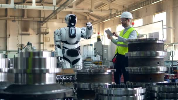 Cyborg está reubicando piezas metálicas bajo supervisión de los trabajadores — Vídeos de Stock