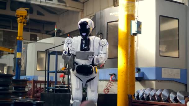 El robot biónico está gestionando una tableta en la unidad de fábrica — Vídeo de stock