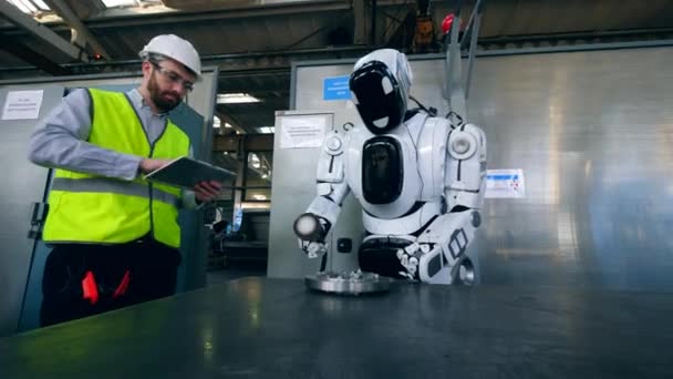 Pracownik fabryki kontroluje Cyborg polerowanie metalowej tarczy — Wideo stockowe