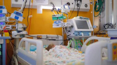 Bir çocuk bir tıbbi birimde bir yatakta uyuyor