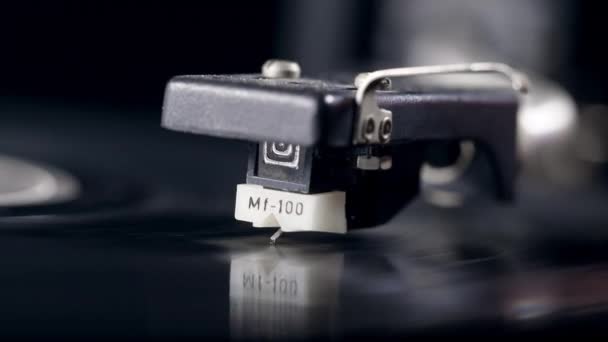 Cartridge is lowering onto a revolving vinyl disc — Stock Video