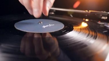 Bir kişi bir vinil disk ile bir kayıt çalar başlatıyor