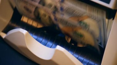 Bankacılık ekipmanları basılı dolar banknotları sayar.