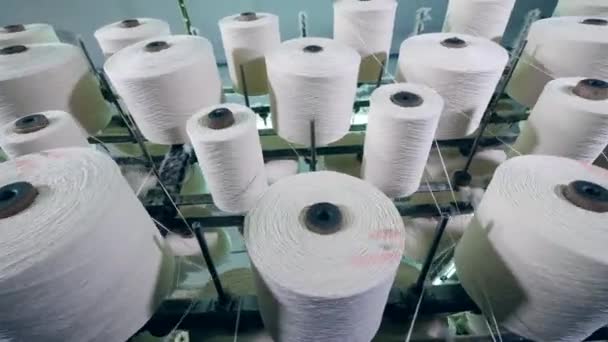 Draaiende klossen met witte draden ontcoiling — Stockvideo