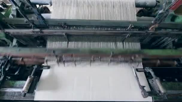 Біла тканина виробляється на промисловому ткацькому верстаті — стокове відео