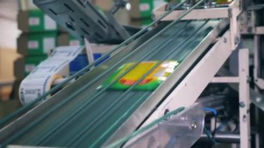 Bir fabrikada otomatik konveyör üzerinde hareket eden plastik ambalaj.