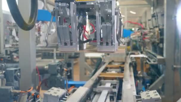 Máquina automatizada pone tapas de cartón en cajas en un transportador . — Vídeo de stock