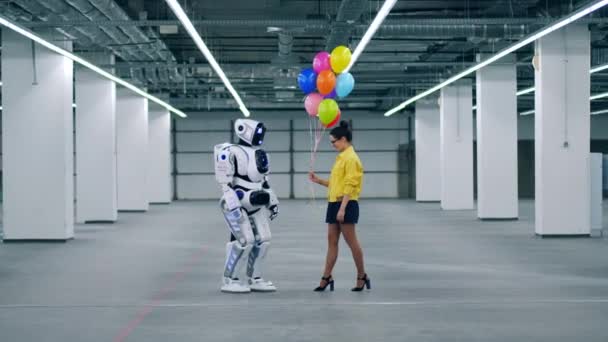 Een meisje geschenken veel kleurrijke ballonnen aan haar vriend Droid. — Stockvideo