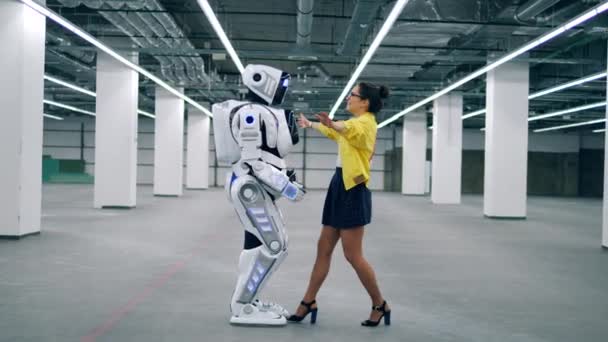 Robot og kvinne som klemmer hverandre, står i et tomt rom . – stockvideo