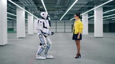 Cyborg ona gülümserken kızların elini tutuyor..