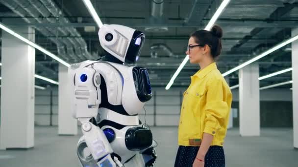 Una chica toca la mano de los cyborgs blancos, mirándola . — Vídeos de Stock