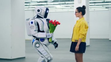 Bir droid bir kıza kırmızı lale verir ve ona sarılır..