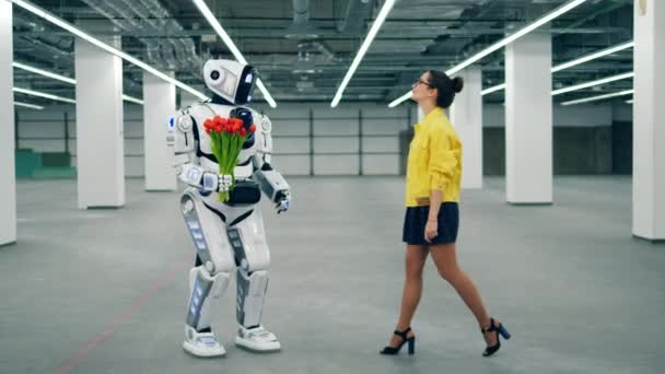 Witte robot geeft een bos van tulpen naar een vrouw. — Stockvideo