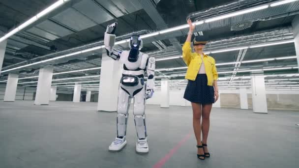Женщина в очках виртуальной реальности управляет дроидом, движущимися руками . — стоковое видео