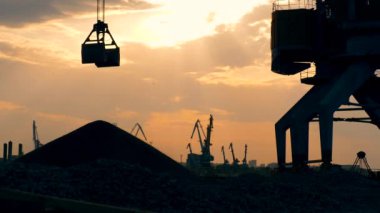 Bir vinç yükü, rıhtımdaki kazıklara kırılan taşları dışarı çıkarır.