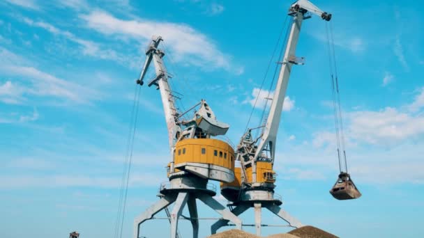 Industrial cranes loading-out breakstones in piles. — Stock Video