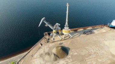 Endüstriyel makineler, kovalarda moloz taşıyan bir mavna boşaltmak.