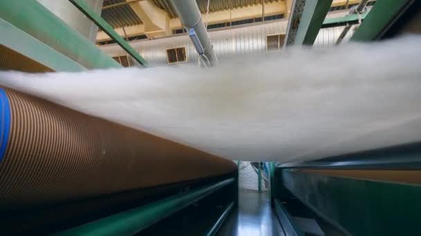 Rolki fabryczne przesuwające warstwę białej tkaniny syntetycznej. — Wideo stockowe