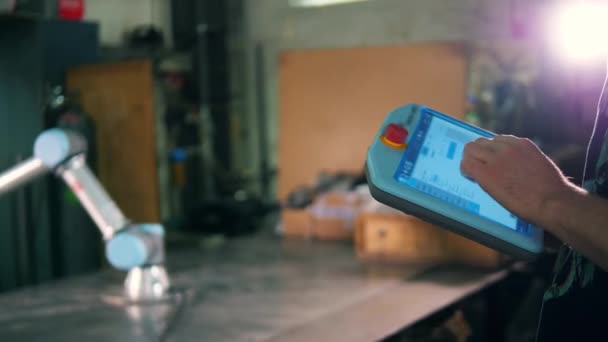 Kişi robotik bir kolu kontrol etmek için tablet kullanır. — Stok video