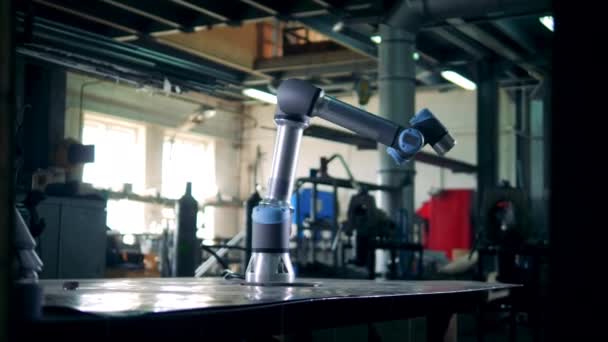 Moderne robotarm werkt met een versnelling op een tafel. — Stockvideo