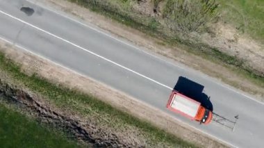 Araba bir banliyö yolunu işaretediyor, şeritleri bölüyor.
