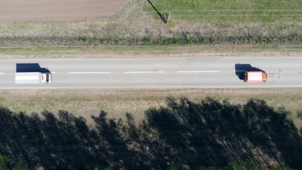 El coche rojo marca el camino en una carretera con pintura blanca . — Vídeos de Stock