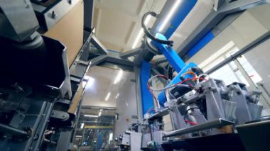 Karton plakalar endüstriyel bir mekanizma tarafından başka bir yere yerleştiriliyor.