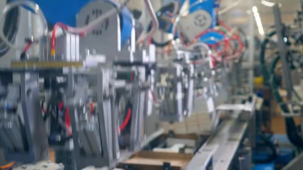 Equipo de fábrica moderno. Mecanismo robótico está reubicando cajas de cartón y el embalaje de ellos — Vídeo de stock