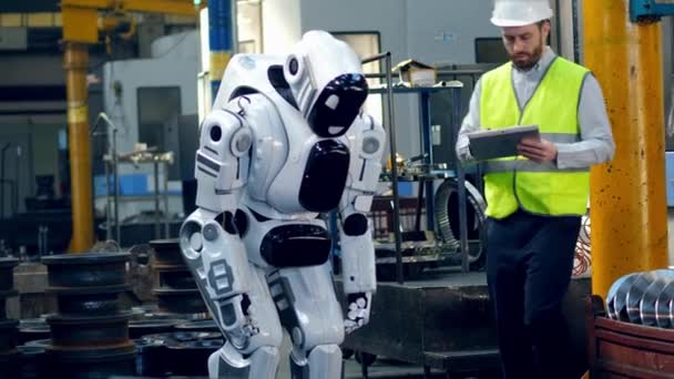 Tall robot is being launched by the male worker — Stock Video