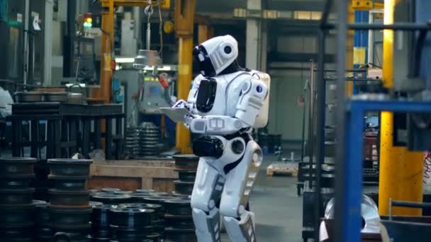 Cybernetic robot är att driva en tablett i en anläggning enhet — Stockvideo