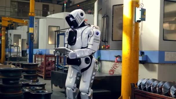 Robô semelhante ao humano está trabalhando com um tablet na fábrica — Vídeo de Stock