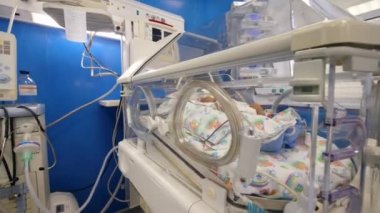 Klinik koğuşta yeni doğmuş bir bebek ile modern bebek kuluçka.