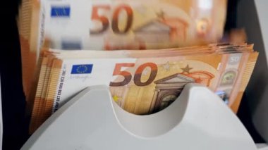 Modern bir makinede otomatik olarak sayılan birçok banknot.