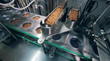 Fabrika mekanizması plastik kapları ekmek kırıntılarıyla dolduruyor