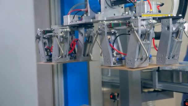 As caixas de cartão estão a ser feitas por um mecanismo robótico. Equipamento de fábrica robótico moderno . — Vídeo de Stock